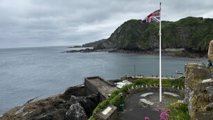 Flaga Wielkiej Brytanii powiewająca na wzgórzu z kaplicą.