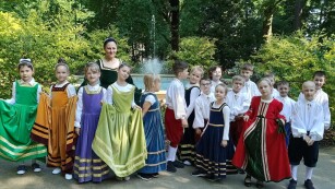 Grupa 17 uczniów w kostiumach typu renesansowego stoi w Parku Saskim